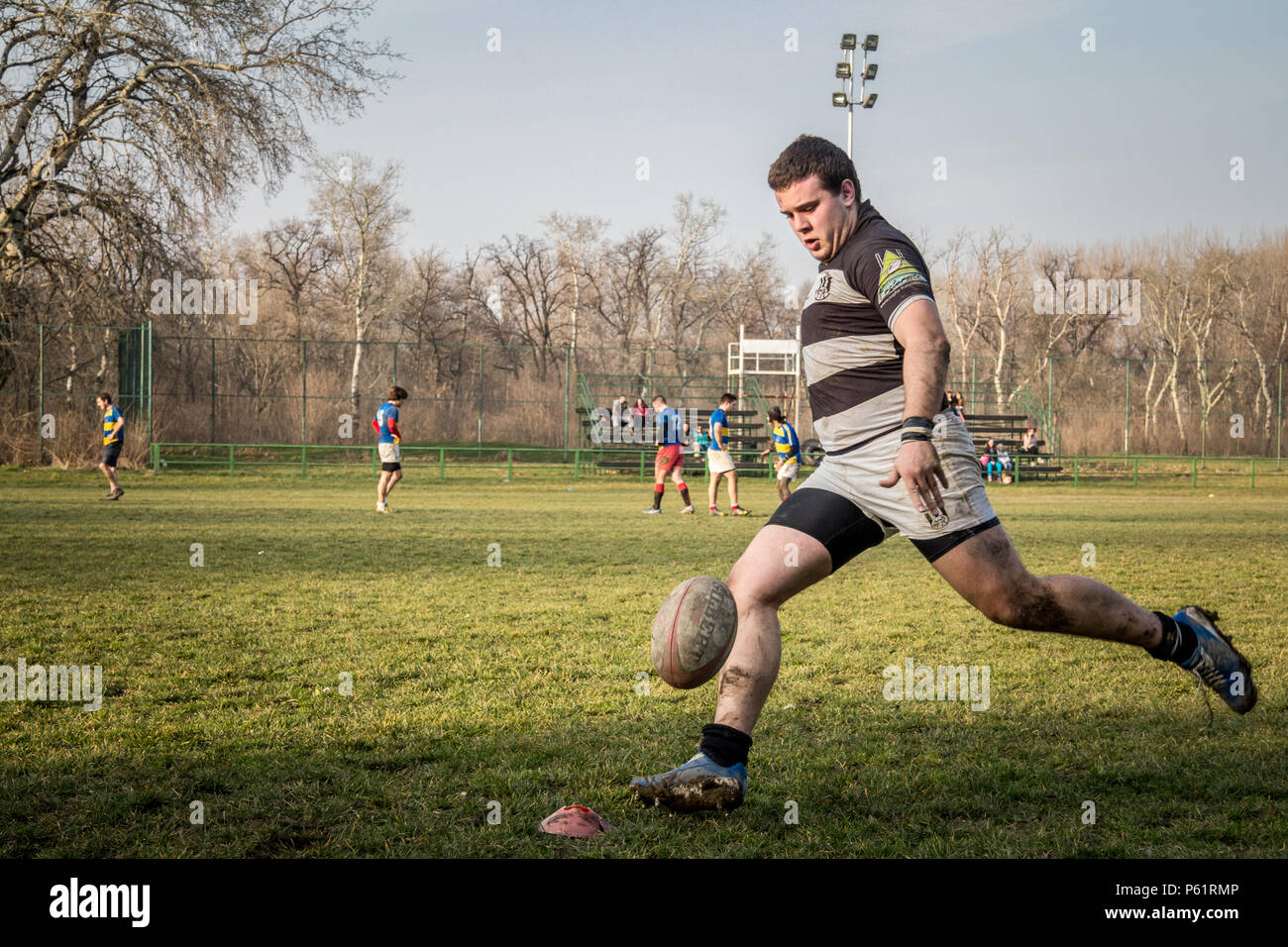 BELGRADE, SERBIA - MARCH 1, 2015:  Young man shooting at a rugby ball doing  Drop Goal  during a Partizan Rugby team training   Picture of white young Stock Photo