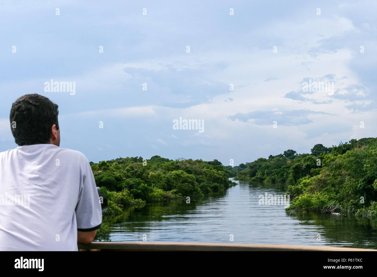 Amazonas, Brazil. A tourist contemplating the beautiful view of the Negro River during the flood season with the Amazon rainforest in the background. Stock Photo