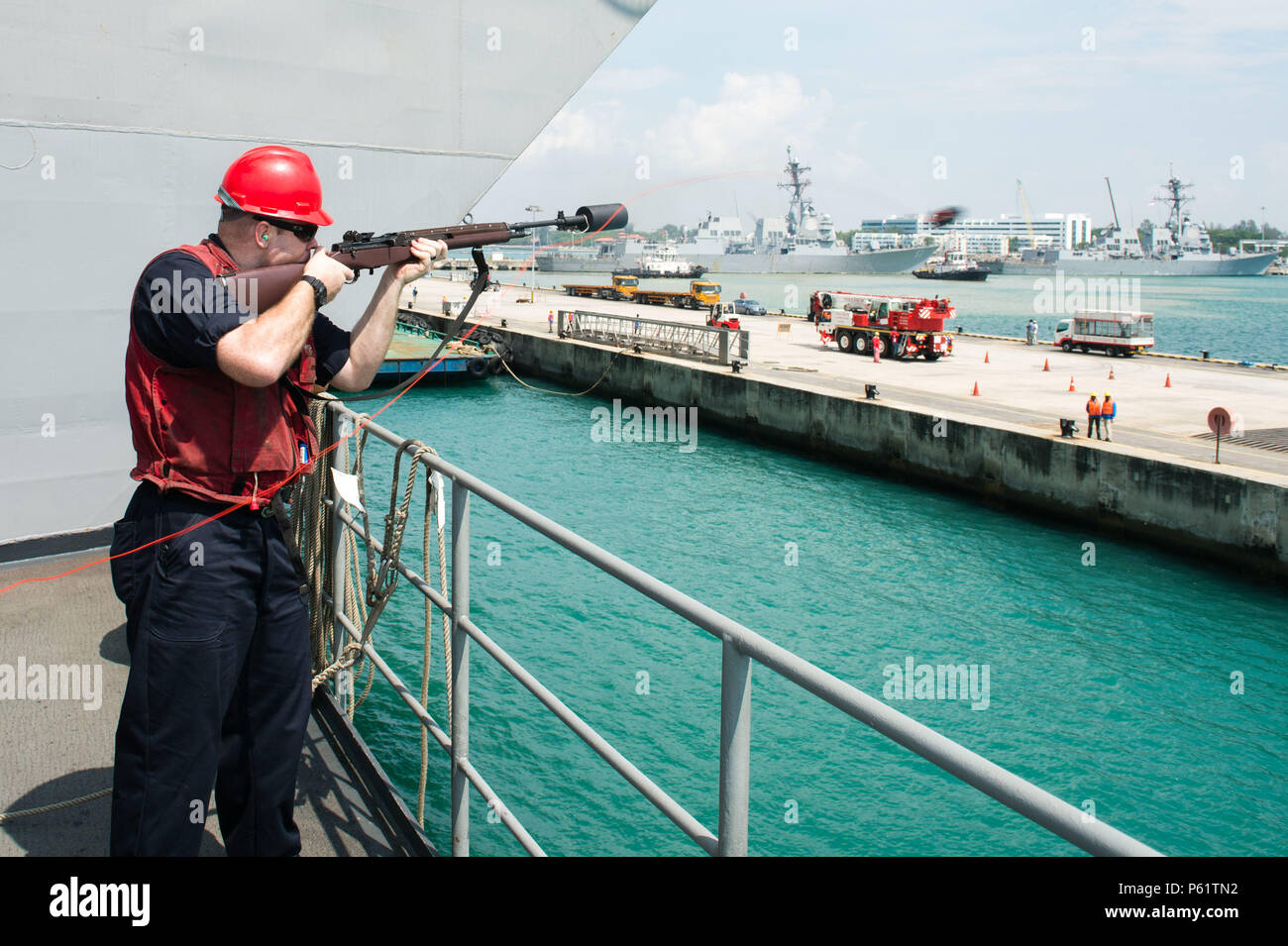 160419-N-XX566-103 SOUTH CHINA SEA (April 19, 2016) - Aviation Ordnanceman 1st Class Benjamin Llewellyn, from Hawthorne, Nev., fires a shot line from USS John C. Stennis' (CVN 74) fantail. Providing a ready force supporting security and stability in the Indo-Asia-Pacific, John C. Stennis is operating as part of the Great Green Fleet on a regularly scheduled 7th Fleet deployment. (U.S. Navy photo by Mass Communication Specialist 3rd Class Andre T. Richard/ Released) Stock Photo
