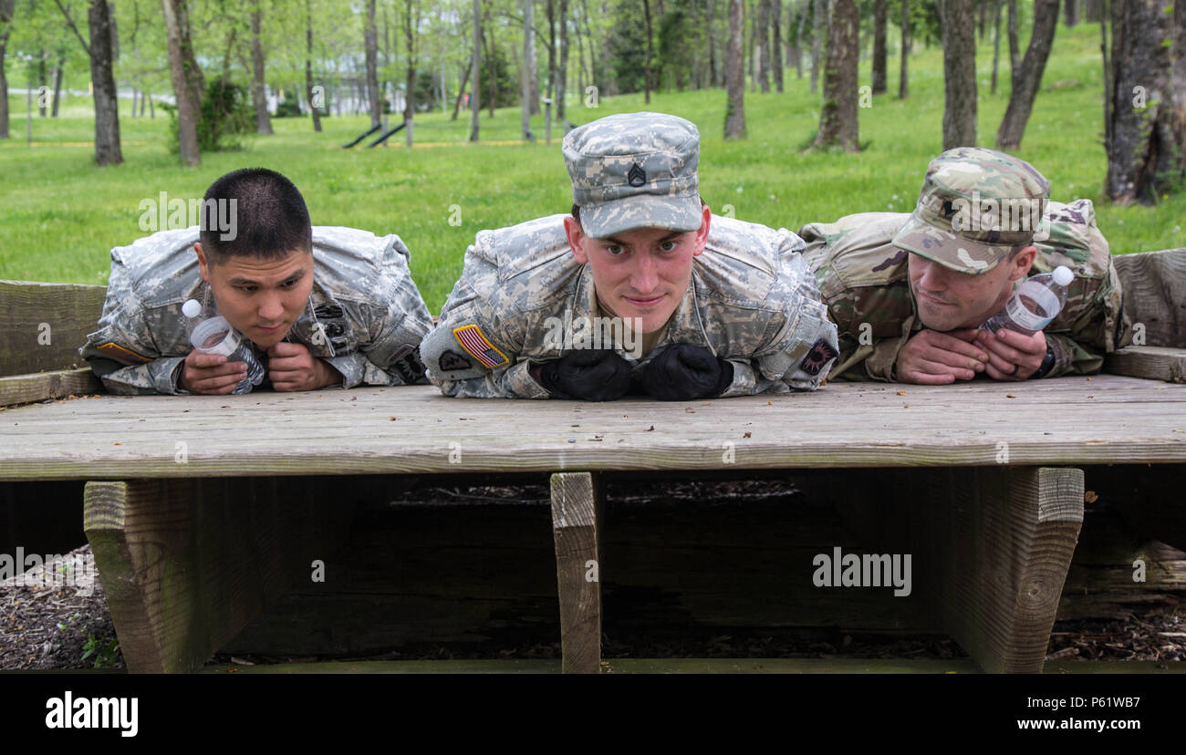 U.S. Army Soldiers, Sgt. James Ahn (left), Staff Sgt. Jesse Harris, and Spc. Jason Green, assigned to the 49th Ordnance Company (EOD), 184th Ordnance Battalion (EOD), balance on an uneven bridge during the Field Leadership Reaction Course for the 52D Ordnance Group (EOD) Team of the Year 2016 competition at the Wendell H. Ford Regional Training Center, Greenville, Ky., April 25, 2016. The weeklong competition tests teams, consisting of 3 EOD technicians, in various scenarios they may encounter in situations around the world, to determine the most physically, mentally, tactically, and technical Stock Photo
