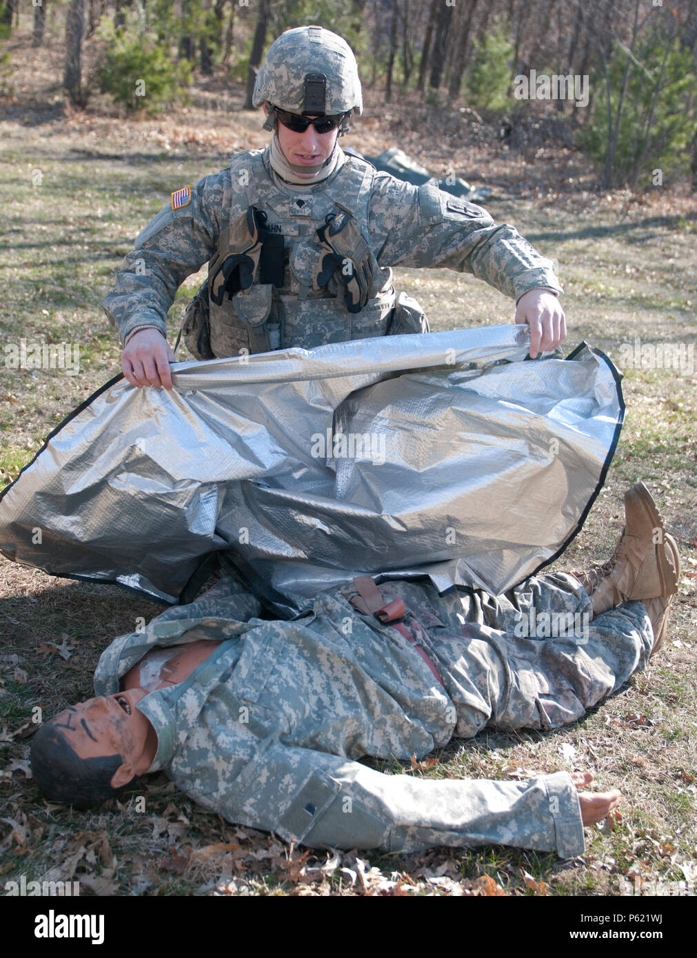 Spc. Alexander Hahn, a rifleman with Company C, 1st Battalion, 128th Infantry Regiment, 32nd Infantry Brigade Combat Team, treats a casualty suffering from shock as part of the Army Warrior Tasks event during the 2016 State Best Warrior Competition at Fort McCoy, Wis., April 9. Five noncommissioned officers and eight Soldiers of the Wisconsin Army National Guard compete in the three-day, state-level event for the opportunity to represent Wisconsin at the upcoming regional best warrior competition at Camp Perry Joint Training Center, Port Clinton, Ohio, in May. (112th Mobile Public Affairs Deta Stock Photo