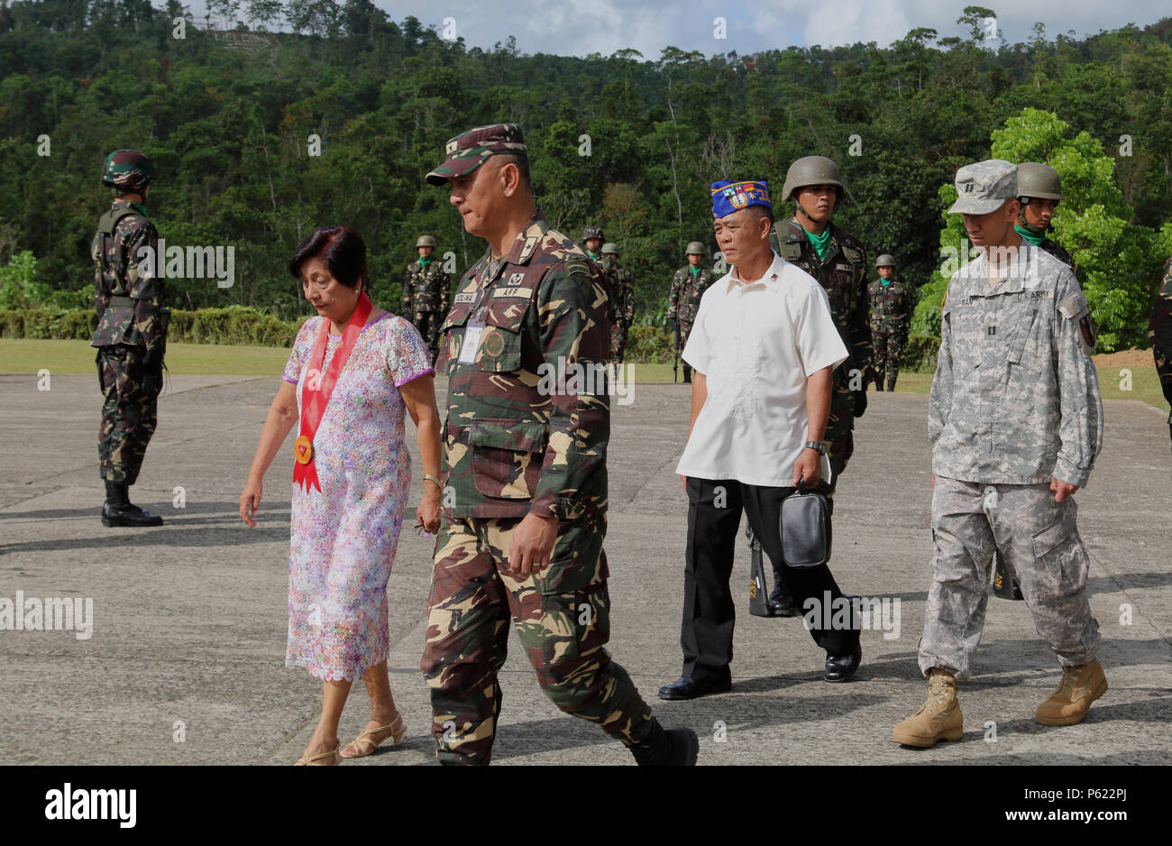 Honorable Ethel R. Jinon, (front, left), Mayor of Jamindan, Capiz, Brig. Gen. Dinoh A. Dolina, Armed Forces of the Philippines (AFP) assistant division commander, 3rd Infantry Division, Retired 2nd Lt. Charlito F. Firma, AFP, and U.S. Army Reserve Cpt. Kevin K. Tran, 303rd Maneuver Enhancement Brigade, operations officer in charge in support of Balikatan 2016 Combined Joint Civil Military Operations Task Force, participates in AFP flag raising ceremony at Camp Peralta, Capiz, Philippines, in memorialization of the historical Bataan Death March of 1942, April 09, 2016.  The ceremony was one of  Stock Photo