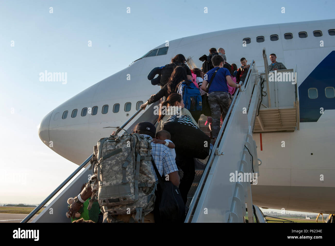 Families of U.S. Airmen and families of Department of Defense civilians  ascend a flight of stairs to board an Atlas Air 747 airliner April 1, 2016  at Incirlik Air Base, Turkey. Department