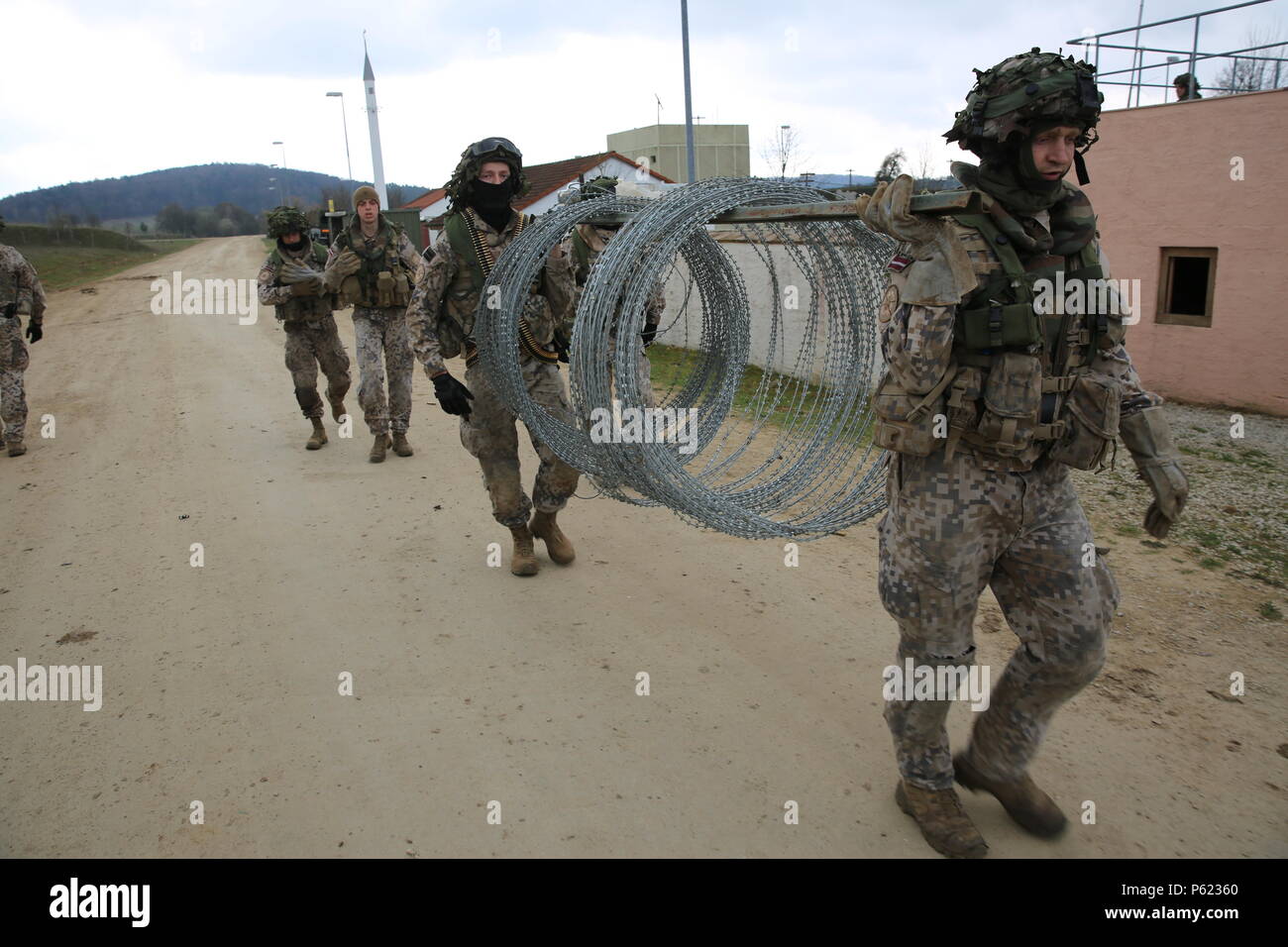 Latvian Soldiers Of Bravo Wolf Company 1st Battalion Latvian Land Forces Transport Concertina Wire To Build Obstacles While Conducting A Simulated Town Defense Scenario During Exercise Saber Junction 16 At The U S Latvian Soldiers Of Bravo Wolf Company 1st Battalion Latvian Land Forces Transport Concertina Wire To Build Obstacles While Conducting A Simulated Town Defense Scenario During Exercise Saber Junction 16 At The U S