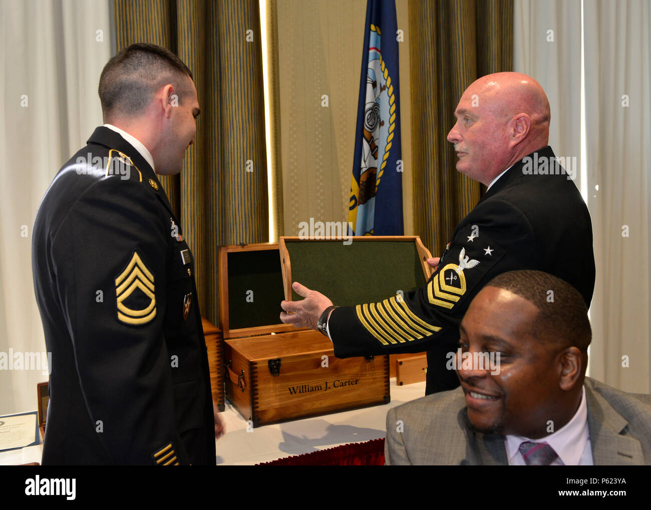NORFOLK, Va. (Apr. 8, 2016) -- Master Chief Ship's Serviceman Kenneth Carter, assigned to Pre-Commissioning Unit Gerald R. Ford (CVN 78) presents his son, Army Sgt. 1st Class Billy Carter, with a keepsake box during his retirement at Vista Point Conference Center at Naval Station Norfolk. Master Chief Carter retired after 30 years of service in the Navy, originally reporting to Recruit Training Command in Orlando, Florida, in 1986. (U.S. Navy photo by Mass Communication Specialist Seaman Apprentice Gitte Schirrmacher/Released) Stock Photo