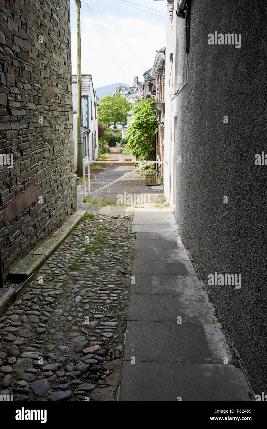 cottages and holiday lets down a narrow pedestrian access cobbled lane Keswick Lake District Cumbria England UK Stock Photo