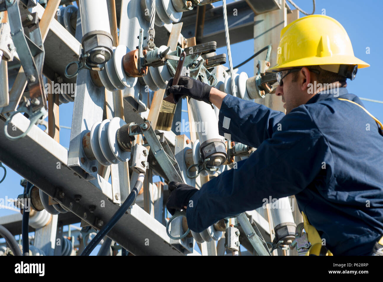 Staff Sgt. Manoj Williams, 375th CES Electrical Systems Craftsman, greases  a sub-station's framework knife blades April 9, 2016 at Scott Air Force  Base, Ill. A scheduled power outage was done to ensure