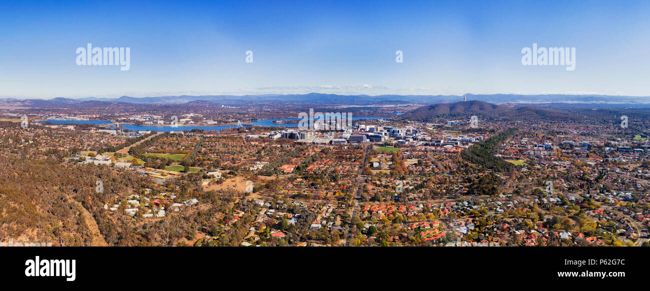 Wide elevated aerial panorama of Canberra city CBD suburb and Capitol hill federal district around lake Burley Griffin. Stock Photo
