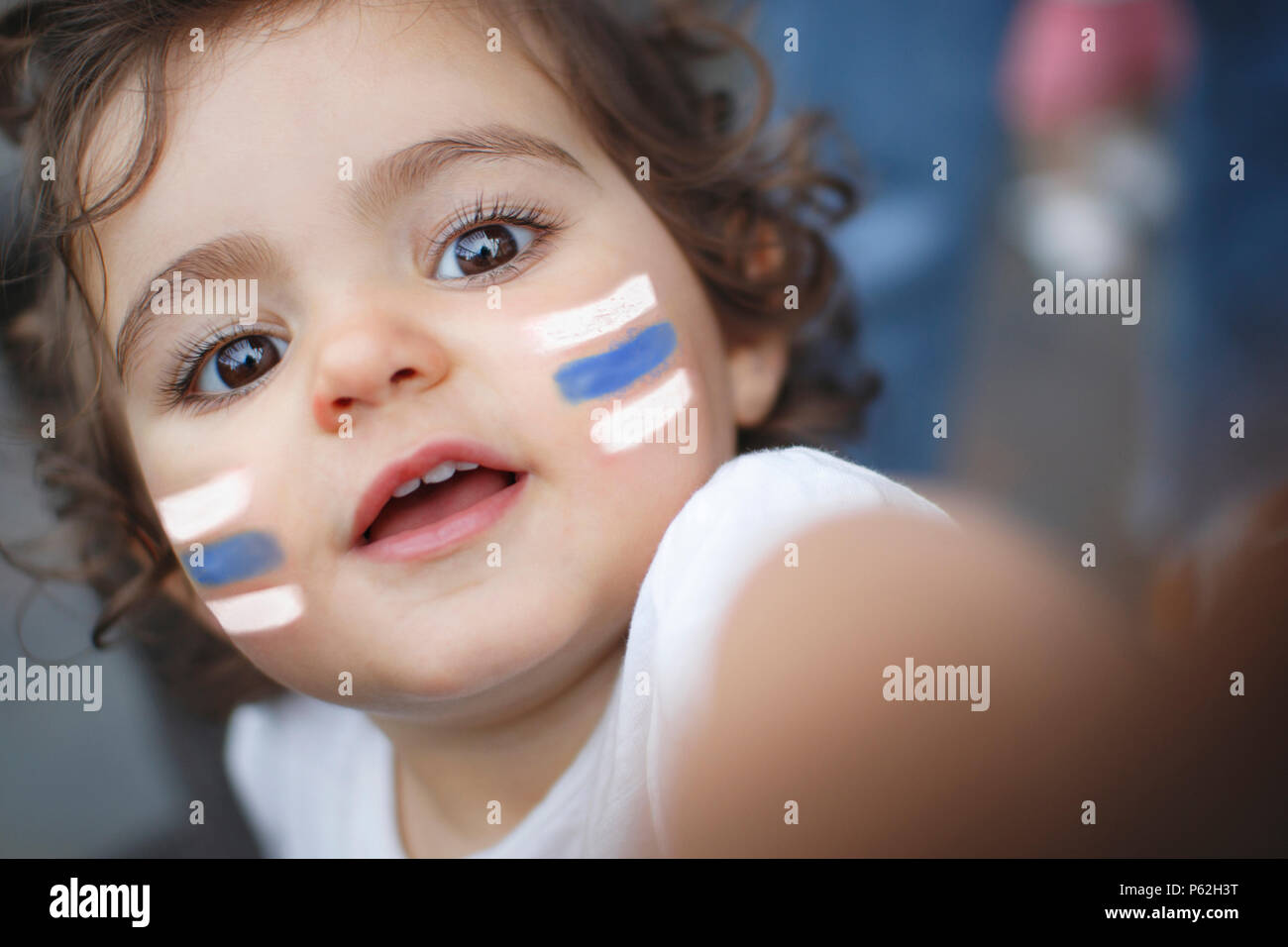 Kid fan with white and blue flag painted on face Stock Photo