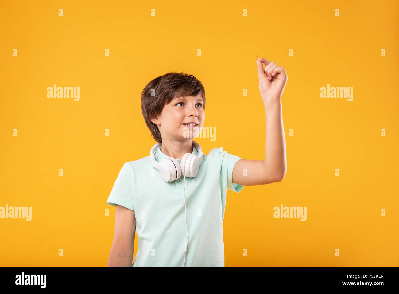 Cheerful preteen holding a tiny pin Stock Photo