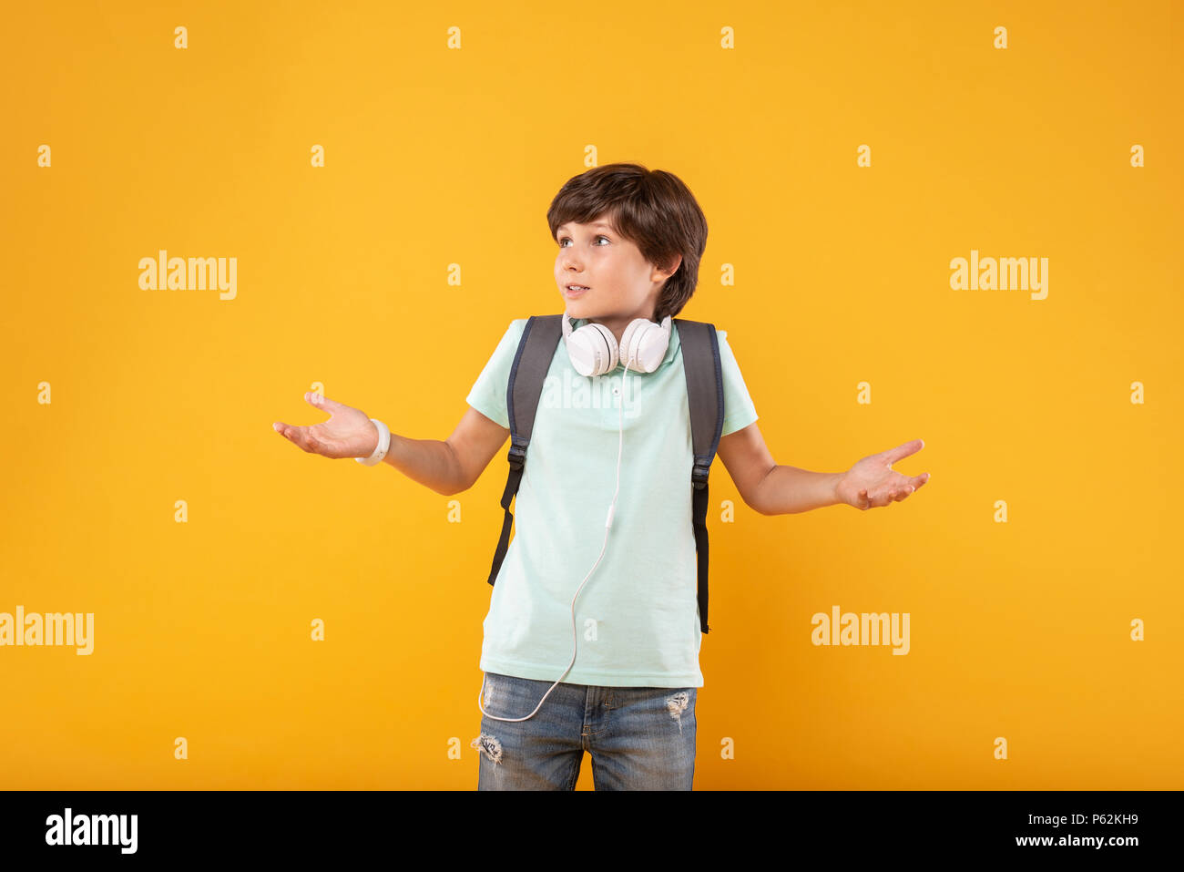 Baffled boy wearing his schoolbag Stock Photo