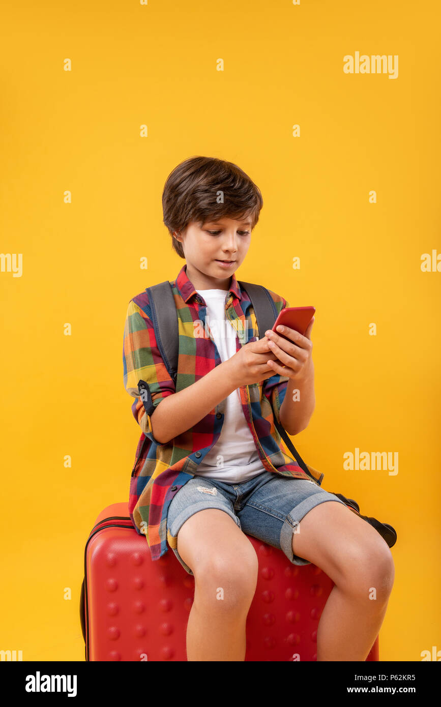 Inspired boy sitting on his luggage Stock Photo
