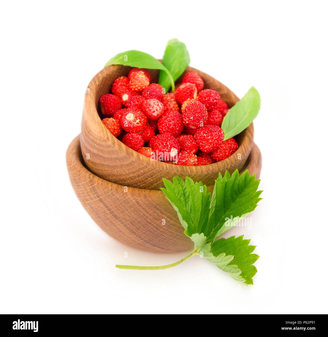 Wild small strawberries in a wooden bowl with leaves. Ripe and tasty ...