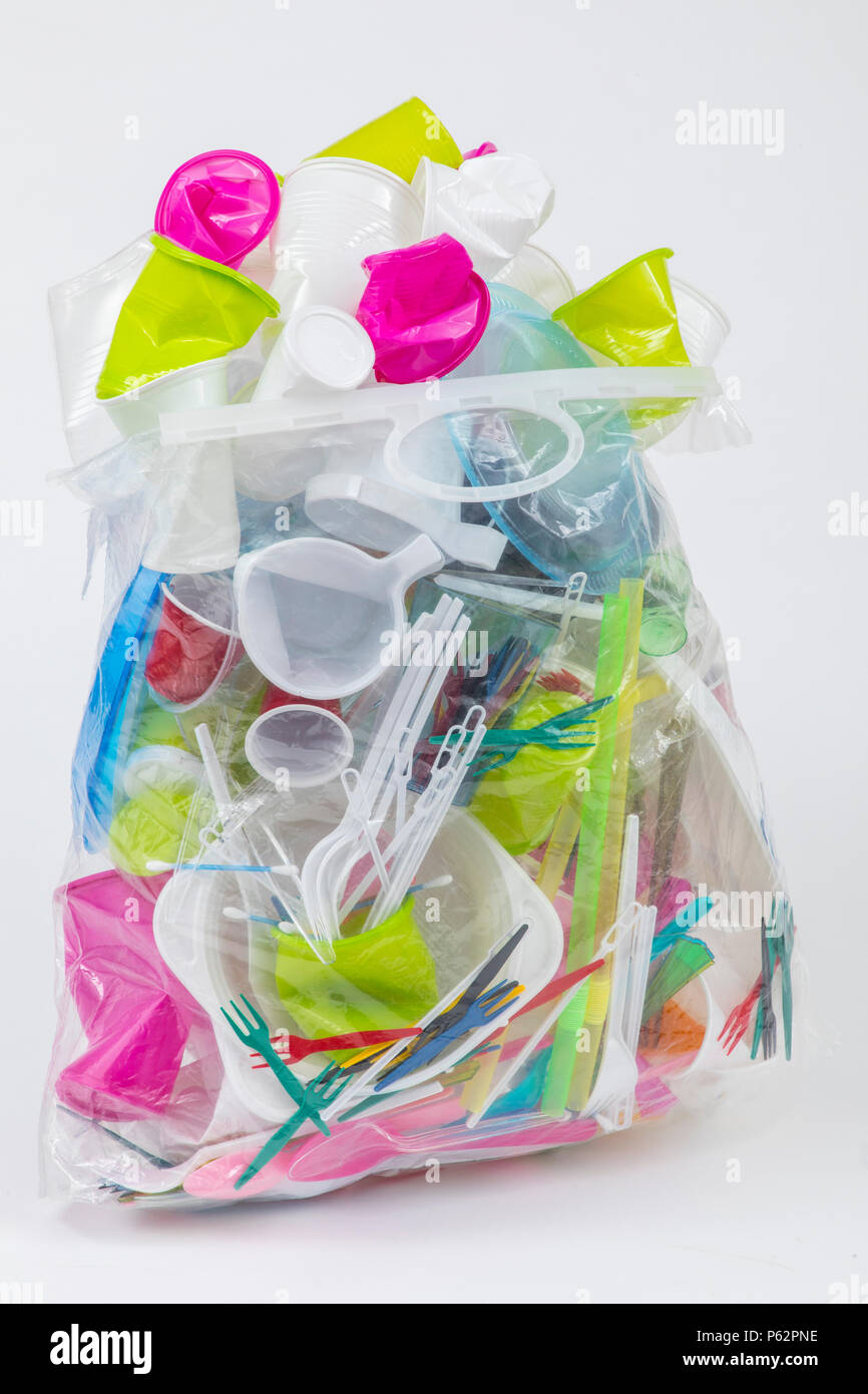 Garbage bag filled with disposable tableware, plastic utensils,  plastic cups, plastic bags and other plastic garbage, various colors, sizes and types Stock Photo