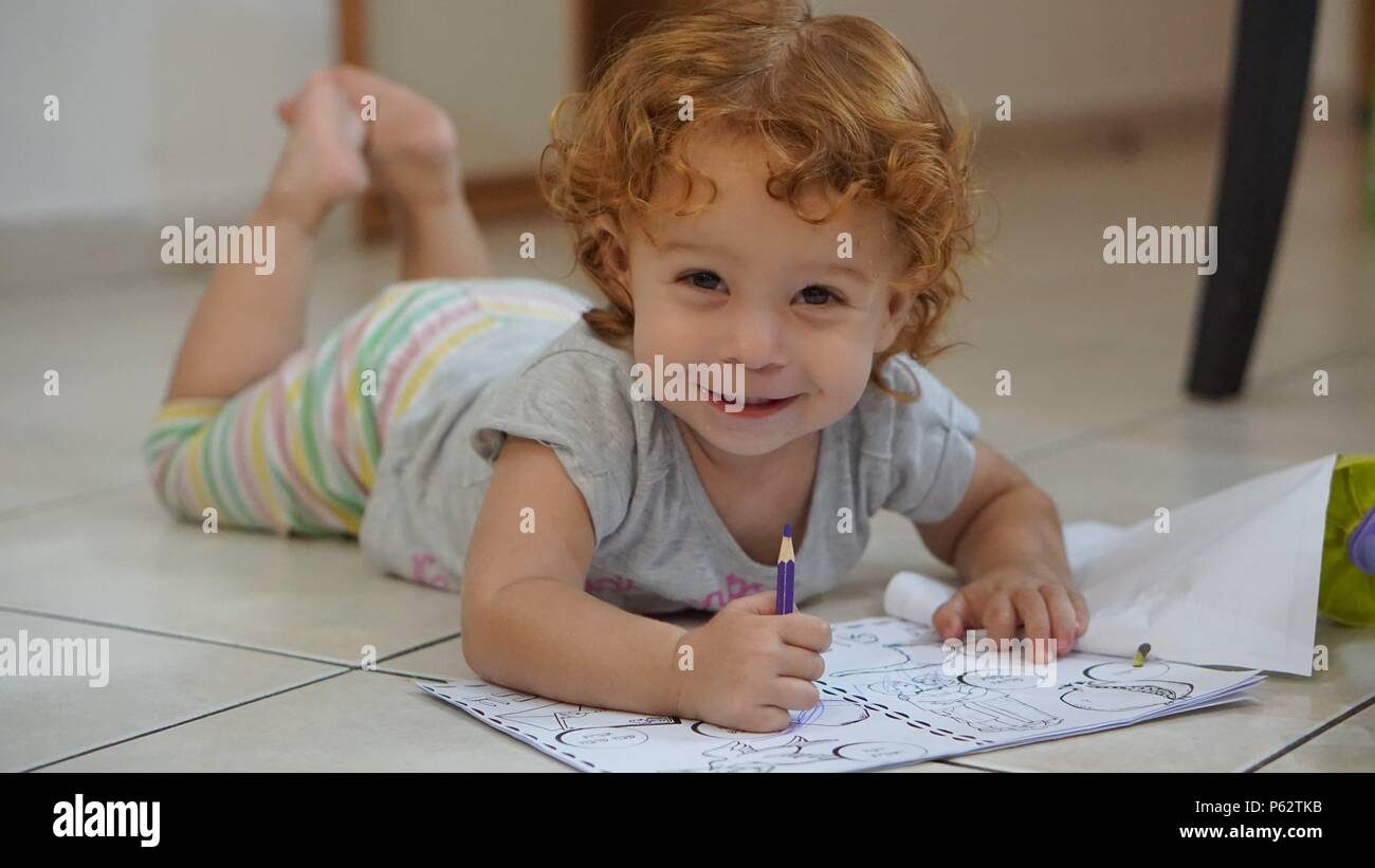 Cute redhead girl lying on floor and drawing Stock Photo - Alamy
