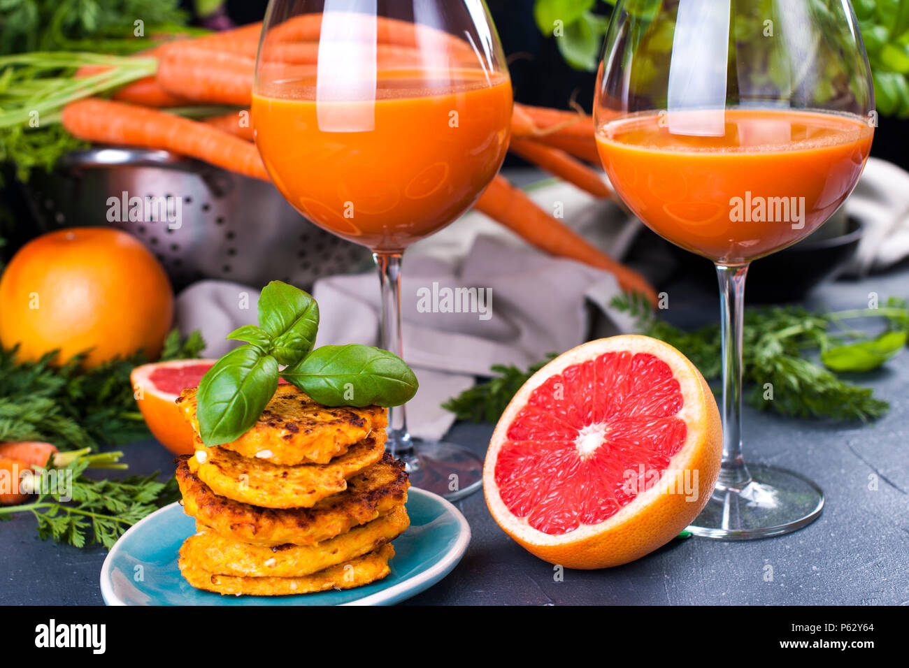 Juice from fresh carrots and grapefruit in a glass and fragrant pancakes for breakfast. vitamin drink for a healthy diet. Vitamins in food. Copy space Stock Photo