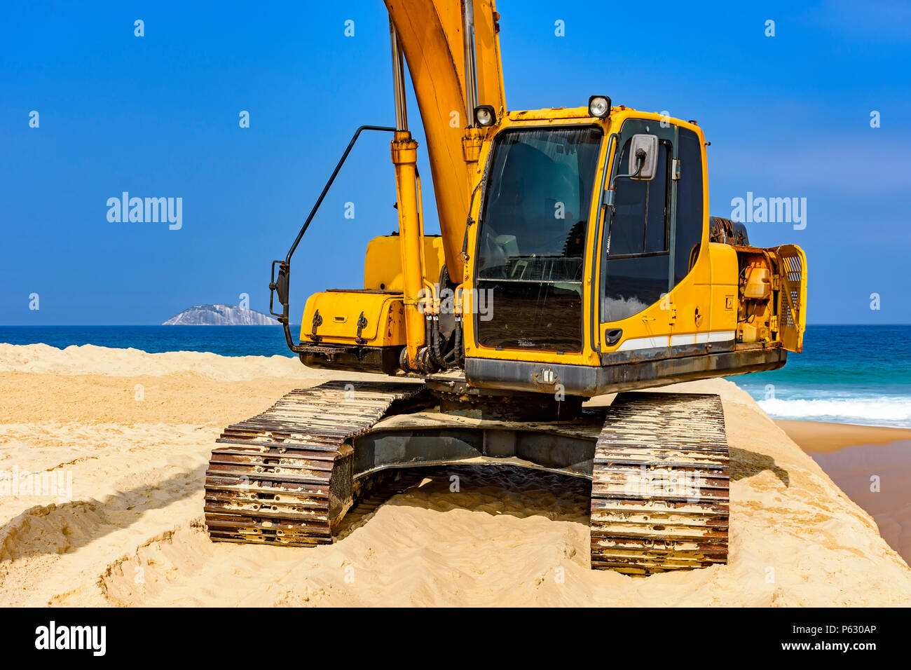Yellow excavator cabin and arm over sand at beach in a sunny day Stock ...