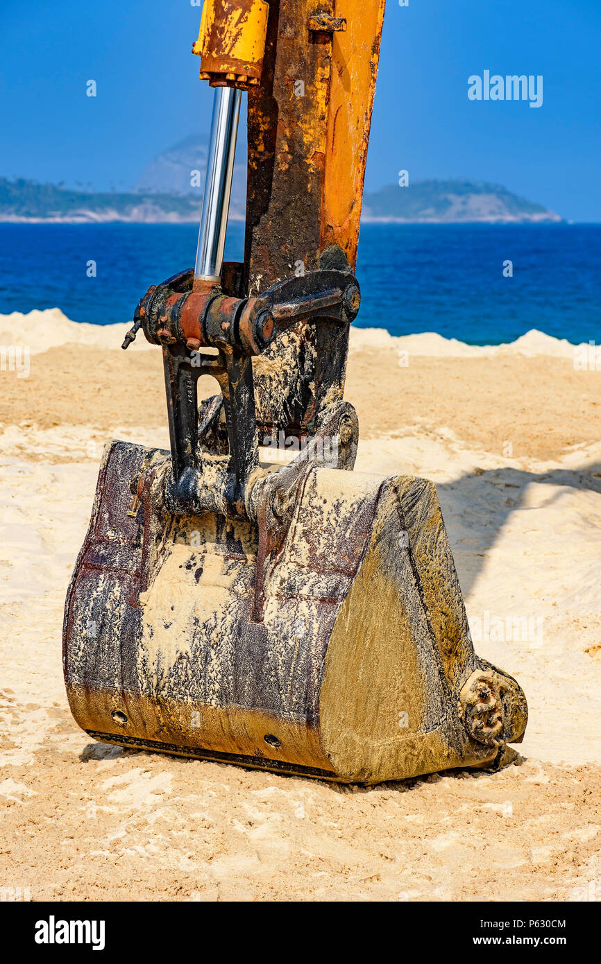 Yellow excavator over sand at beach in a sunny day Stock Photo - Alamy