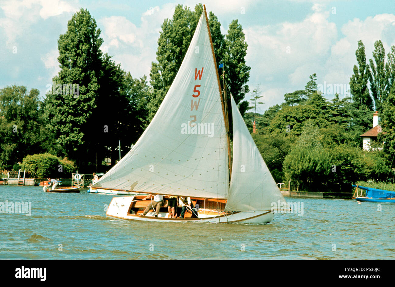 Three man sailing small yacht, Oulton Broad, Suffolk, England Stock Photo