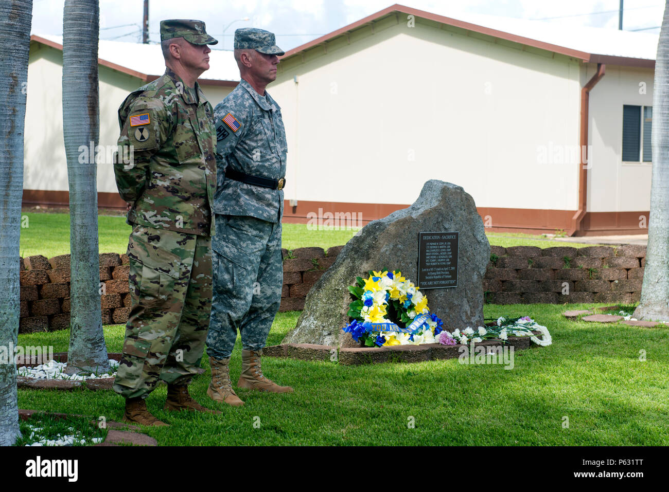 The Defense POW/MIA Accounting Agency (DPAA) Senior Enlisted Leader Sgt. Maj. Mike Swam and Deputy Director Brig. Gen. Mark Spindler stand at attention next to the memorial monument during a memorial service for seven service members that lost their lives in a helicopter crash on Apr. 7, 2001.  The ceremony was conducted today on Joint Base Pearl Harbor-Hickam to honor the sacrifice and memory of the service members. The DPAA works to provide the fullest possible accounting of missing personnel to their families and the nation.  (DoD photo by MC3 Armando Velez/Released) Stock Photo