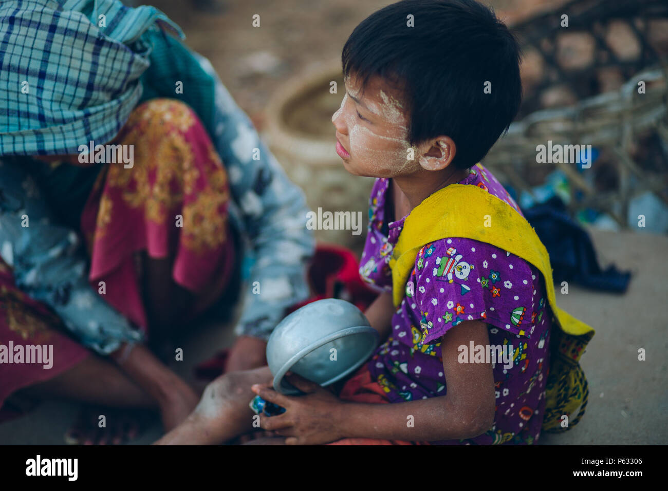 Bagan, Myanmar - FEB 21th 2014: Young Asian Burmese girl wait for food on the street Stock Photo
