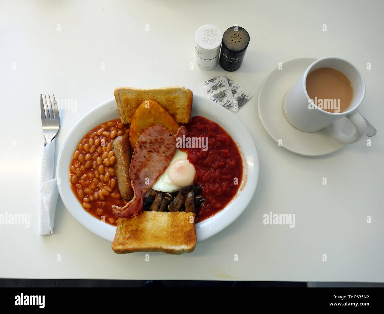 Full English all day Breakfast in a Sheffield cafe. Bacon, Egg, Tinned Tomatoes,Hash Browns, Beans, Sausage, Mushrooms with toast and of course a good Stock Photo
