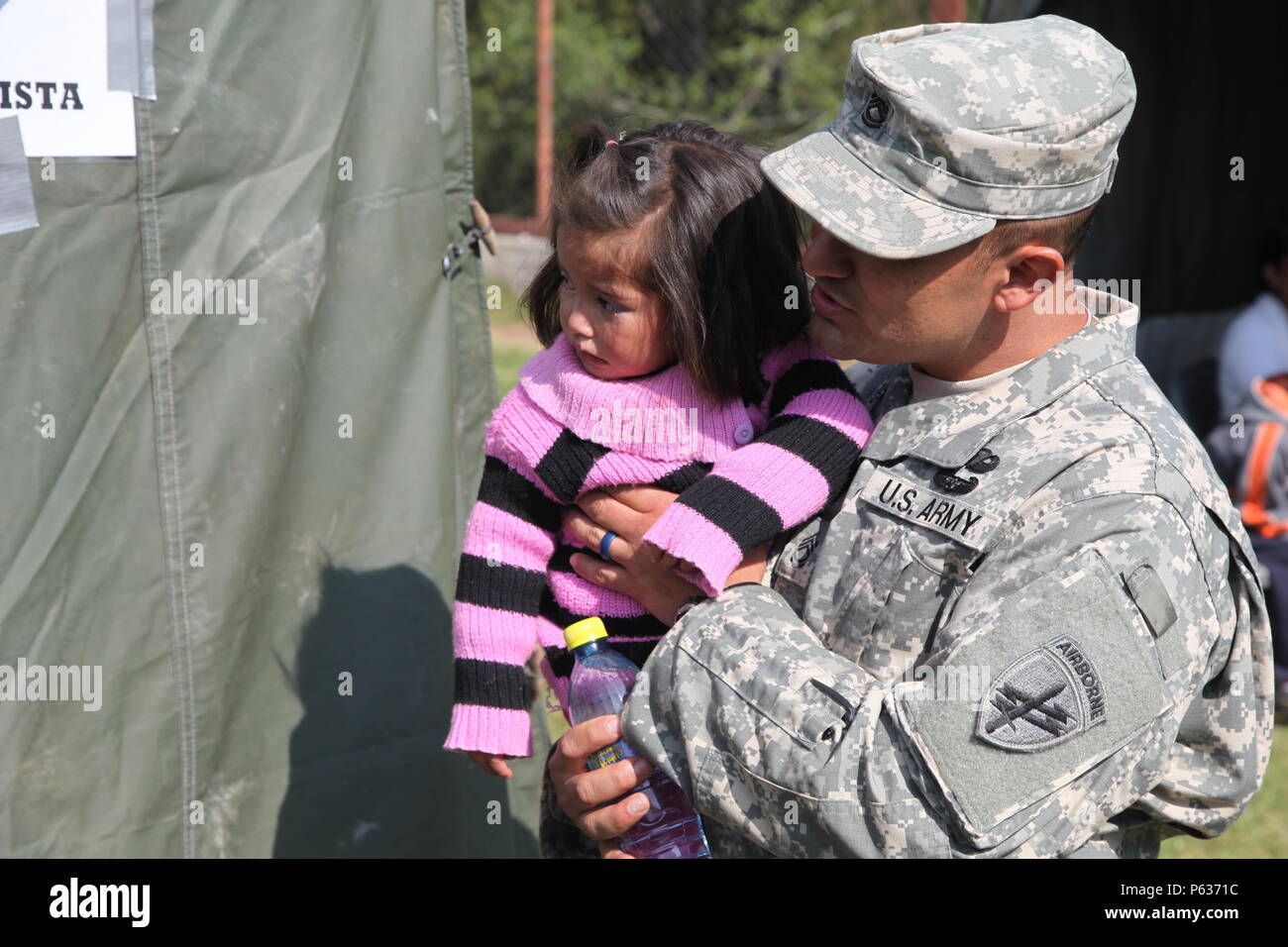 U.S. Army Ssg. Luis Pena takes time to comfort local Guatemalan child after receiving treatment as a part of humanitarian efforts of the Beyond the Horizon exercise at San Marcos, Guatemala, April 16, 2016. Task Force Red Wolf and Army South conducts Humanitarian civil Assistance Training to include tactical level construction projects and medical readiness Training Exercises providing medical access and building schools in Guatemala with the Guatemalan government and non government agencies from 05Mar16 to 18JUN16 in order to improve the mission readiness of US Forces and to provide a lasting Stock Photo