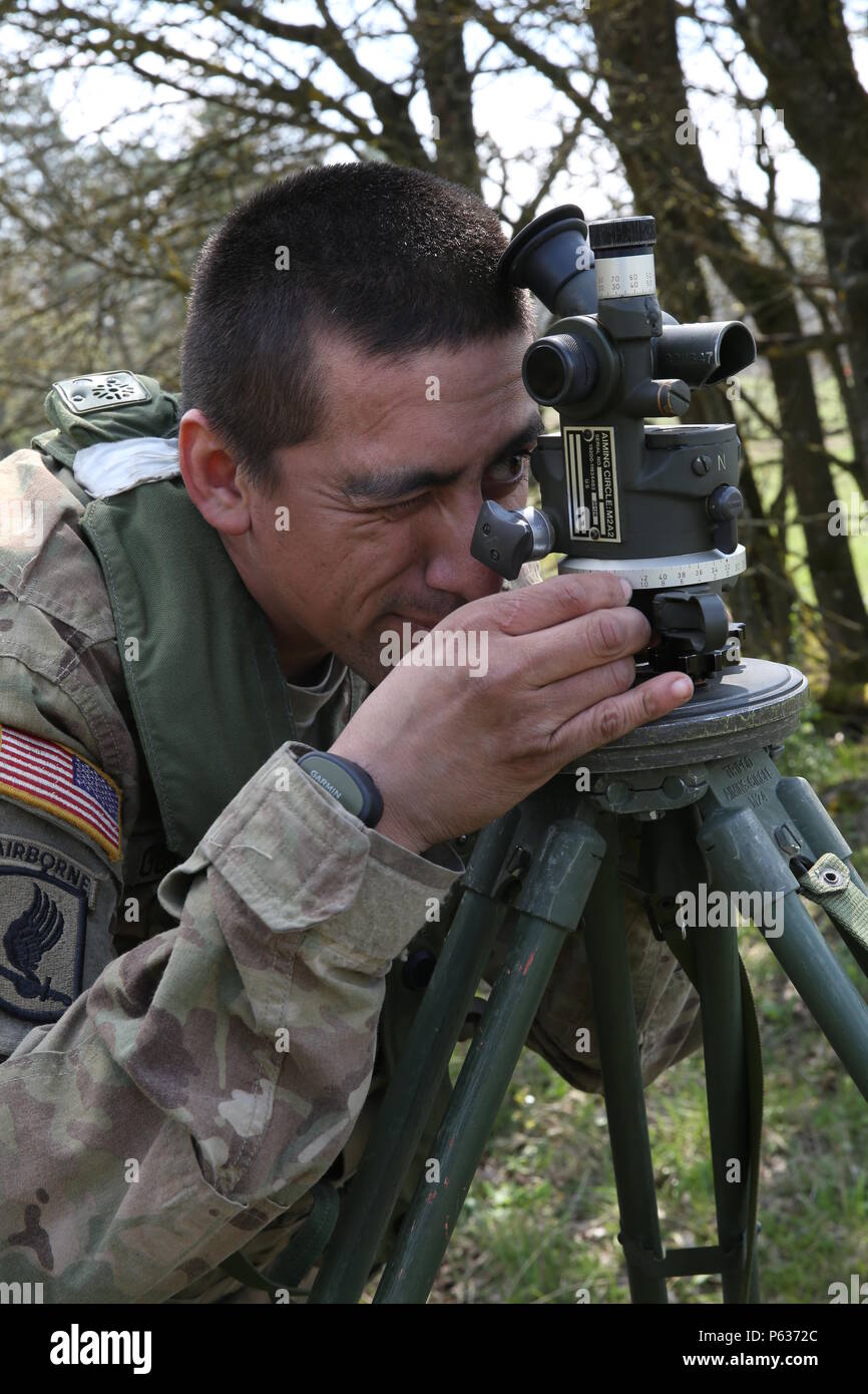 U.S. Army Sgt. David Gonzalez of 4th Battalion, 319th Airborne Field Artillery Regiment, 173rd Airborne Brigade looks through an M2A2 aiming circle while conducting a site survey during exercise Saber Junction 16 at the U.S. Army’s Joint Multinational Readiness Center (JMRC) in Hohenfels, Germany, April 14, 2016. Saber Junction 16 is the U.S. Army Europe’s 173rd Airborne Brigade’s combat training center certification exercise, taking place at the JMRC in Hohenfels, Germany, Mar. 31-Apr. 24, 2016.  The exercise is designed to evaluate the readiness of the Army’s Europe-based combat brigades to  Stock Photo