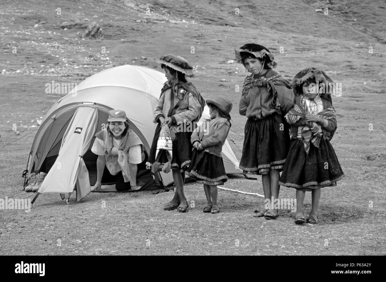 Local QUECHUA girls visit a trekker in her tent - AUZANGATE TREK, PERUVIAN ANDES Stock Photo