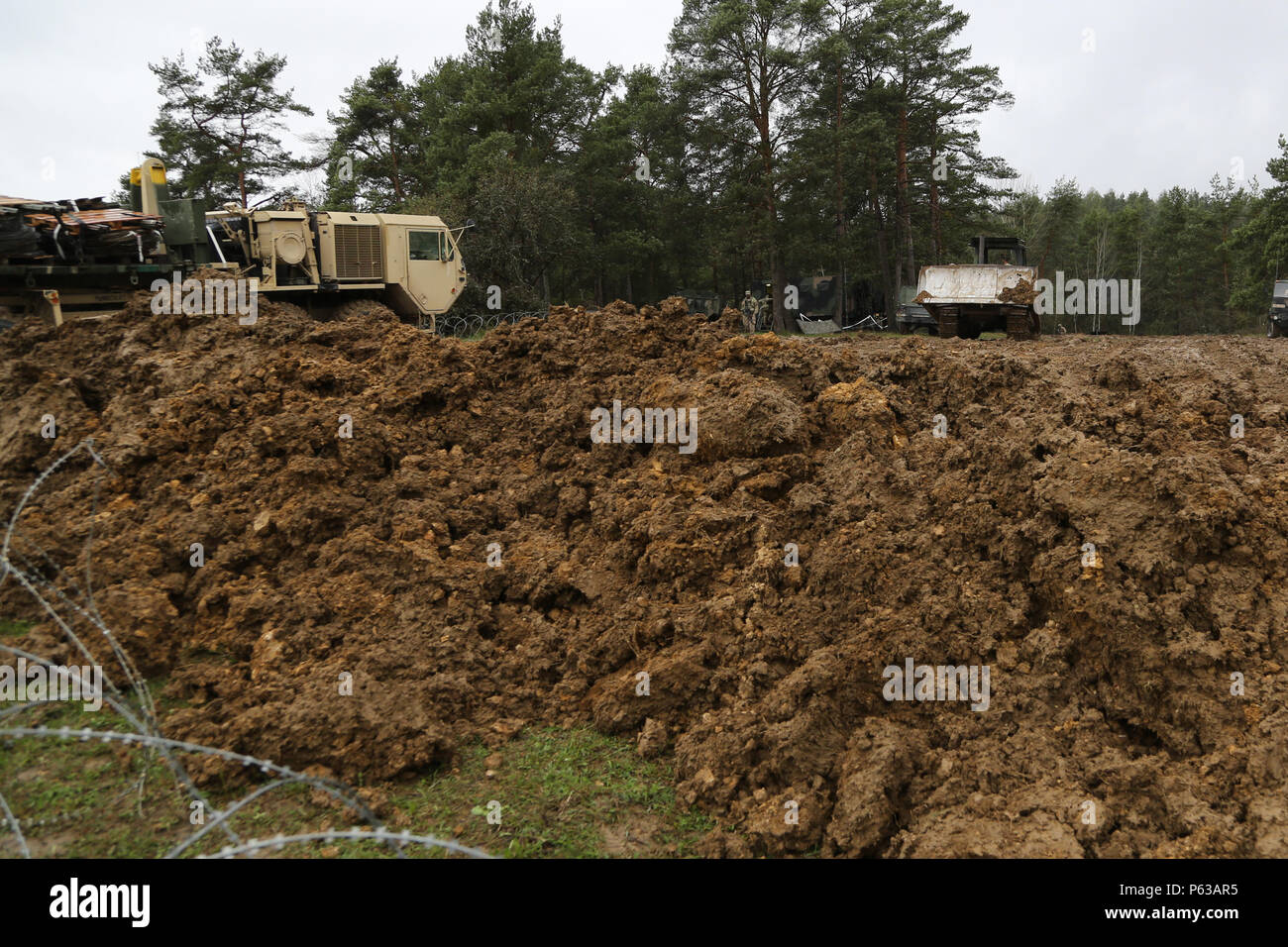 U.S. Soldiers of Fox Company, 4th Battalion, 319th Airborne Field Artillery Regiment, 173rd Airborne Brigade build a berm while constructing defensive obstacles during exercise Saber Junction 16 at the U.S. Army’s Joint Multinational Readiness Center (JMRC) in Hohenfels, Germany, April 17, 2016. Saber Junction 16 is the U.S. Army Europe’s 173rd Airborne Brigade’s combat training center certification exercise, taking place at the JMRC in Hohenfels, Germany, Mar. 31-Apr. 24, 2016.  The exercise is designed to evaluate the readiness of the Army’s Europe-based combat brigades to conduct unified la Stock Photo