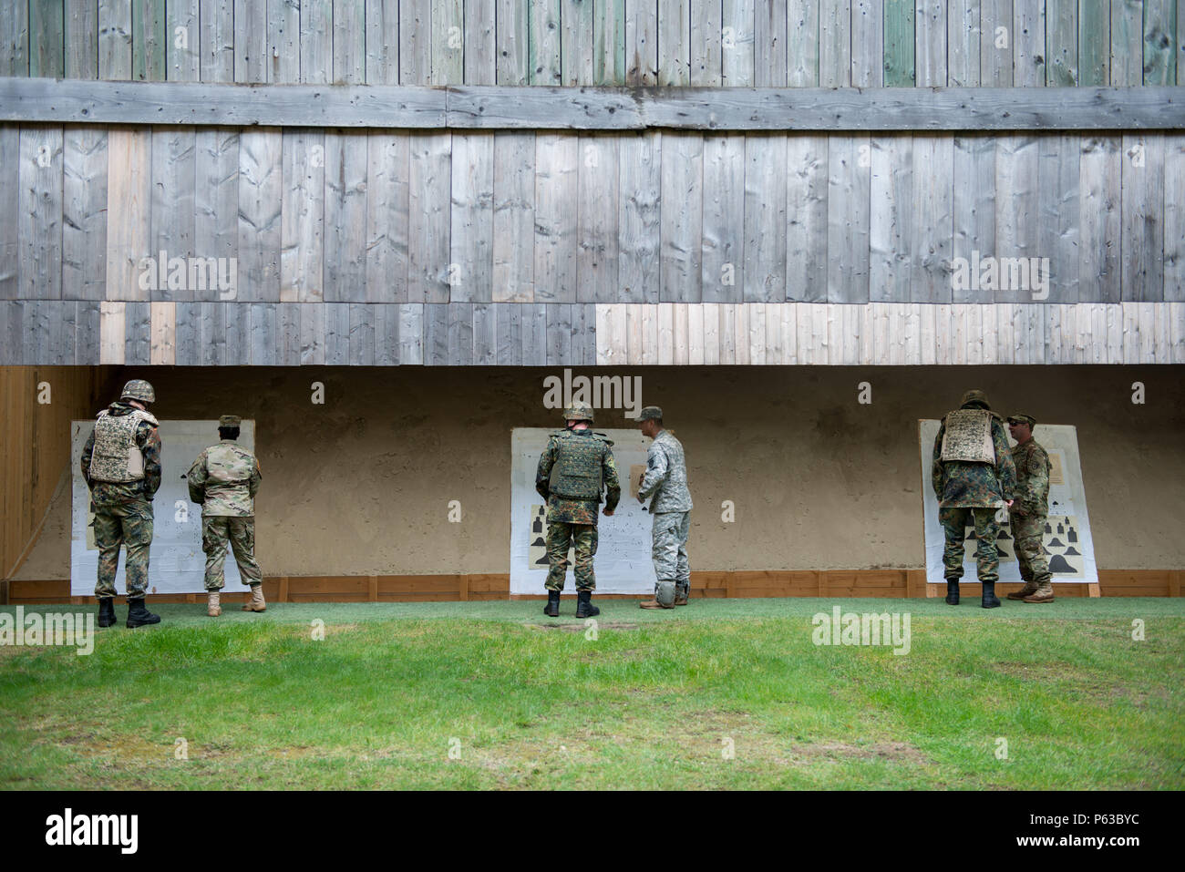 U.S. Soldiers with Alpha Company, Allied Forces North Battalion, U.S. Army NATO Brigade, comment the zeroing performed by German Soldiers assigned to Joint Forces Command Brunssum, who qualify with an M4 carbine in the Dutch Army outdoor firing range in Budel, the Netherlands, April 13, 2016.This qualification session led by Alpha Company was the first with participation of Allied forces assigned to JFC Brunssum. (U.S. Army photo by Visual Information Specialist Pierre-Etienne Courtejoie/Released) Stock Photo