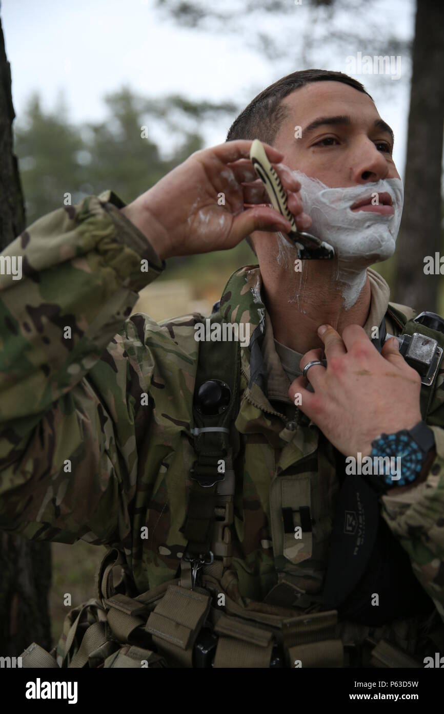 A U.S. Soldier of 173rd Airborne Brigade shaves his face while conducting personal hygiene during exercise Saber Junction 16 at the U.S. Army’s Joint Multinational Readiness Center (JMRC) in Hohenfels, Germany, April 18, 2016. Saber Junction 16 is the U.S. Army Europe’s 173rd Airborne Brigade’s combat training center certification exercise, taking place at the JMRC in Hohenfels, Germany, Mar. 31-Apr. 24, 2016.  The exercise is designed to evaluate the readiness of the Army’s Europe-based combat brigades to conduct unified land operations and promote interoperability in a joint, multinational e Stock Photo