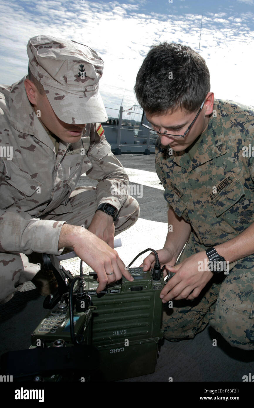 U.S. Marine Corps Cpl. Matthew T. Ramirez, (right), a radio operator with Special Purpose Marine Air-Ground Task Force-Crisis Response-Africa and a Spanish Marine radio operator, (left), with 7th company, 2nd Battalion test a PRC 117F for satellite communications aboard the ESPS Juan Carlos I during Amphibious Exercise 16.1, Apr. 18, 2016. AMPHIBEX is a bilateral exercise centered around the integration of amphibious assets from U.S. and Spanish forces. (U.S. Marine Corps photo by Sgt. Kassie L. McDole/Released) Stock Photo