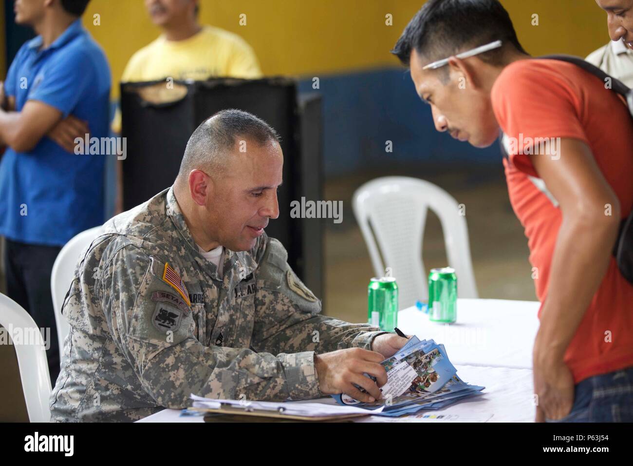 U.S. Army Sgt. 1st Class Luis Villarreal from the 345th Psychological Operations Company hands out flyers to advertise the future Medical Readiness Exercise to the local Cocodes as part of the Beyond The Horizon Operation at San Pablo, Guatemala, April 29, 2016. Task Force Red Wolf and Army South conducts Humanitarian Civil Assistance Training to include tactical level construction projects and Medical Readiness Training Exercises providing medical access and building schools in Guatemala with the Guatemalan Government and non-government agencies from 05MAR16 to 18JUN16 in order to improve the Stock Photo