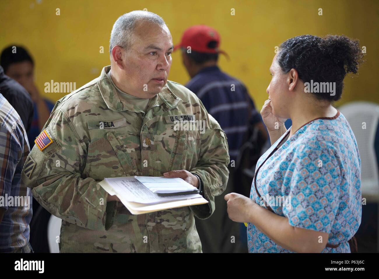 U.S. Army Maj. Edward Vela from the 413th Civil Affairs Battalion talks with a Guatemalan citizen informing her about the upcoming Medical Readiness Exercise as part of the Beyond The Horizon Operation at San Pablo, Guatemala, April 29, 2016. Task Force Red Wolf and Army South conducts Humanitarian Civil Assistance Training to include tactical level construction projects and Medical Readiness Training Exercises providing medical access and building schools in Guatemala with the Guatemalan Government and non-government agencies from 05MAR16 to 18JUN16 in order to improve the mission readiness o Stock Photo