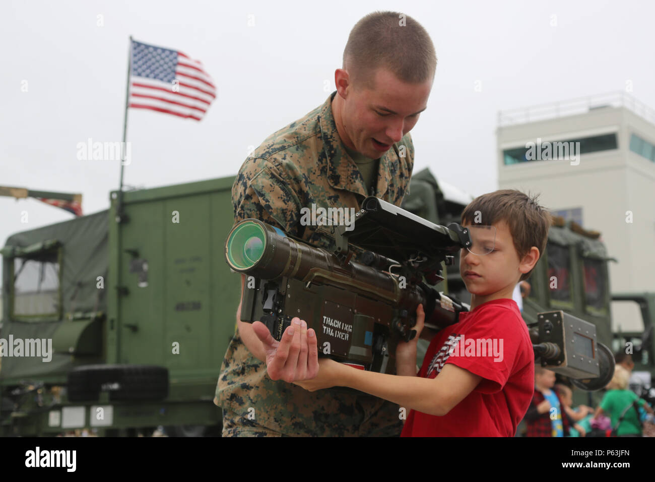 Cpl. Tyler Shiels, a low altitude air defense gunner with 2d Low Altitude Air Defense Battalion  assists Nathan, age 7 as he looks through the sights of a weapon during the 2016 MCAS Cherry Point Air Show – “Celebrating 75 Years” at Marine Corps Air Station Cherry Point, N.C., April 30, 2016. This year’s air show celebrated MCAS Cherry Point and 2nd Marine Aircraft Wing’s 75th anniversary with our biggest line-up of military demonstration teams including the U.S. Navy Blue Angels, the U.S. Air Force F-22 Raptor, the USMC F-35B Lightning II and many more. Stock Photo