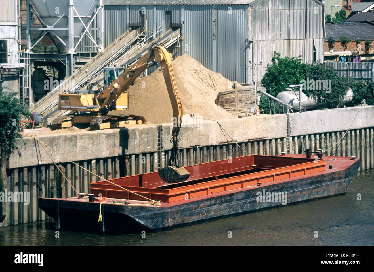 Hanson sand and gravel unloading wharf with a barge of sand being unloaded. Thames river
