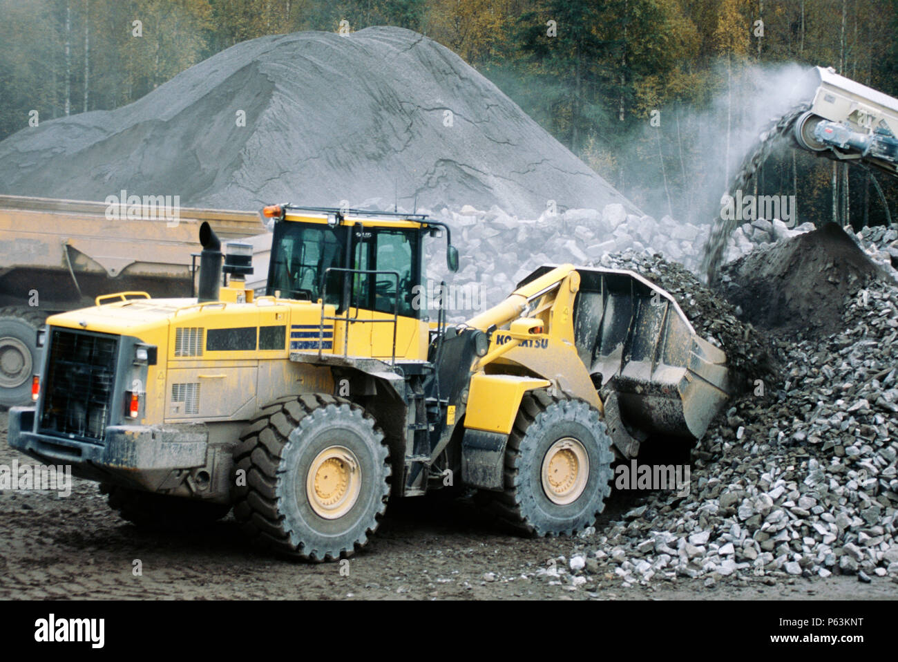 Rock excavated from tunnels on the Bothnia railway in Sweden is crushed at a mobile plant yard and loaded for use elsewhere Stock Photo