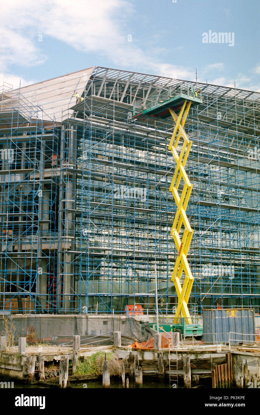 Large size scissor lift used for access on the new convention centre building under construction in Melbourne, Australia Stock Photo