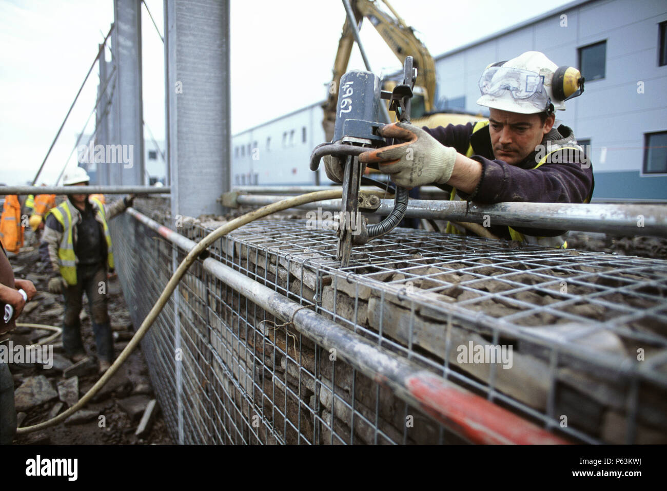 Clipping together wire cages for stone filled  gabions Stock Photo