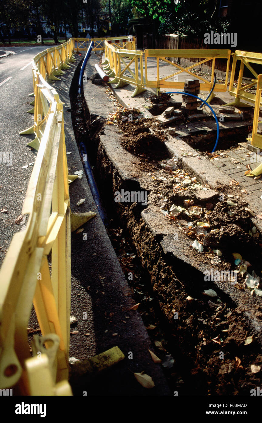 Yellow plastic safety barriers around a trench for water pipe