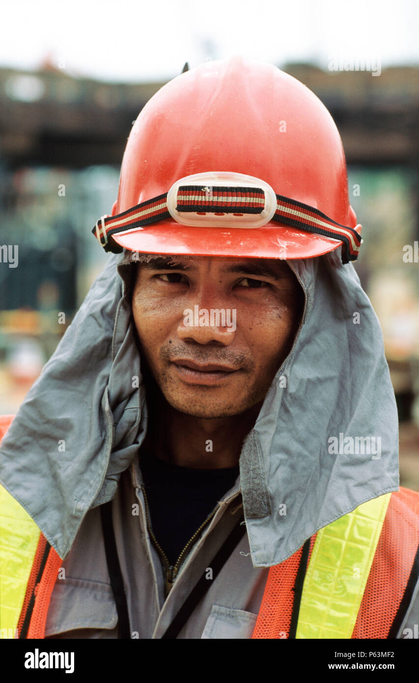 Worker on site in Singapore with sun protection cloth under helmet