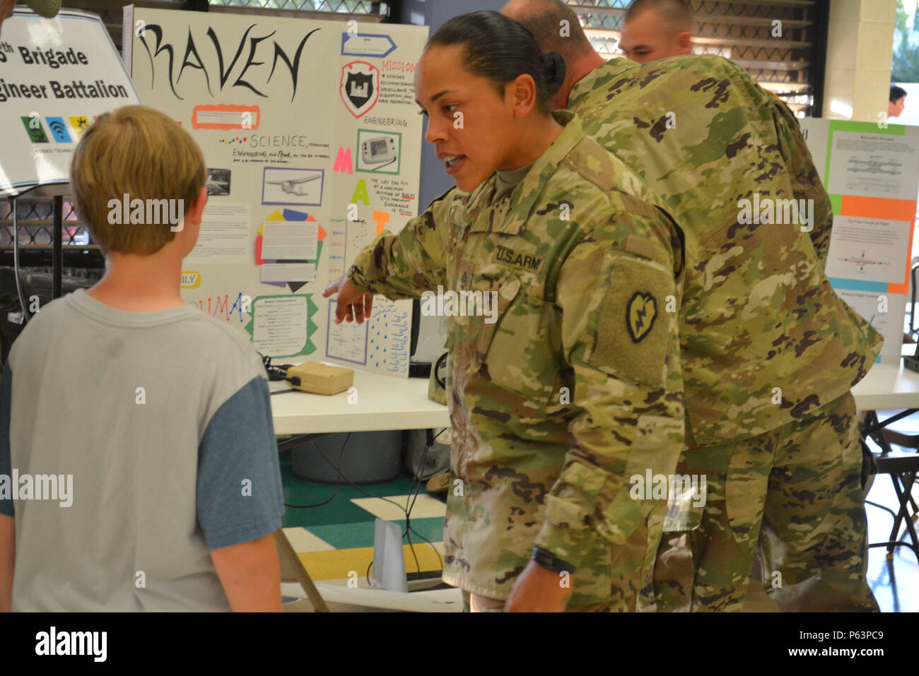 MILILANI, Hawaii – Sgt. Candice Jones, a combat engineer assigned to 65th Brigade Engineer Battalion, 2nd Brigade Combat Team, 25th Infantry Division, talks to a student about the RQ-11 Raven Unmanned Aircraft System during the science, technology, engineering and math education (STEM) night Apr. 9, 2016, at Mililani Middle School in Mililani, Hawaii. Events such as these improve relationships between Soldiers and the community and provides a chance for Soldiers to interact with families and students. (U.S. Army photo by Staff Sgt. Carlos Davis, 2nd Stryker Brigade Combat Team Public Affairs). Stock Photo