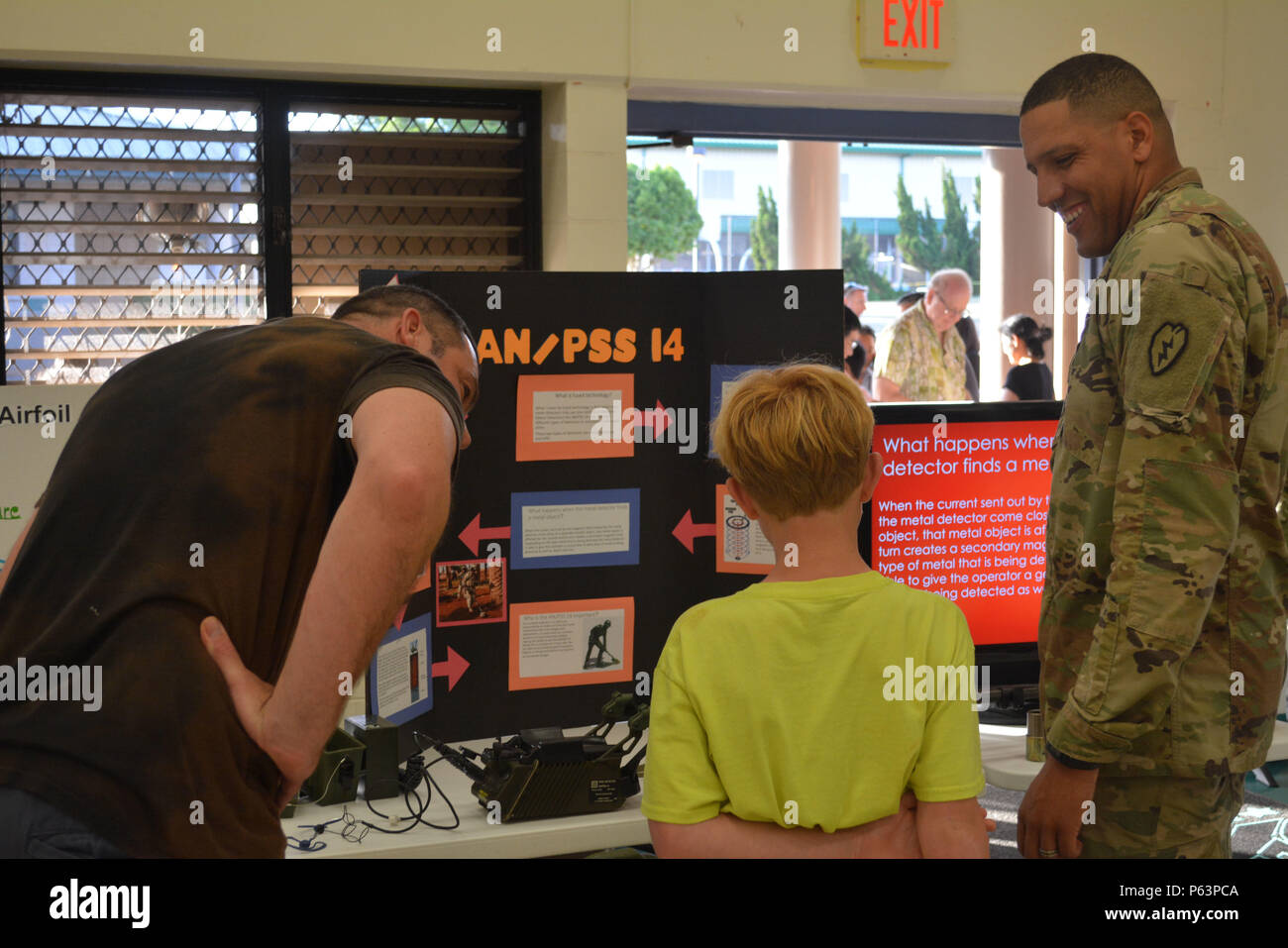 MILILANI, Hawaii – Sgt. Anthony Wallace, a combat engineer with Company A, 65th Brigade Engineer Battalion, 2nd Brigade Combat Team, 25th Infantry Division, talks with a family about the AN/PSS-14 Mine Detection System during science, technology, engineering and math education (STEM) night Apr. 9, 2016, at Mililani Middle School in Mililani, Hawaii. Events such as these improve relationships between Soldiers and the community and provides a chance for Soldiers to interact with families and students. (U.S. Army photo by Staff Sgt. Carlos Davis, 2nd Stryker Brigade Combat Team, 25th Infantry Div Stock Photo