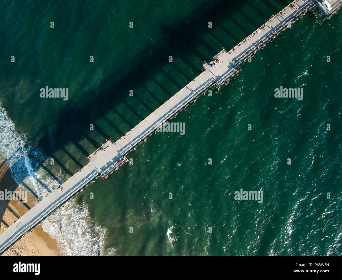 An aerial shot at 330 feet/100 meters looking down on a Southern California  pier located on a small peninsula. White foam from crashing waves and vibr  Stock Photo - Alamy