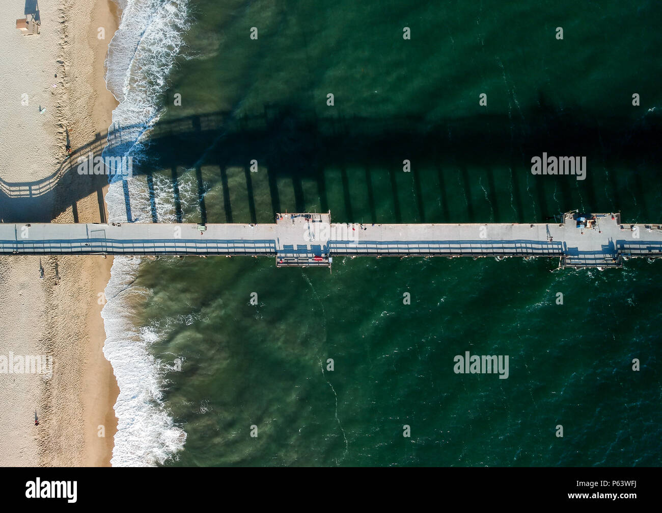 An aerial shot at 330 feet/100 meters looking down on a Southern California pier located on a