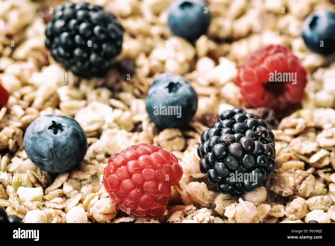 Raspberry, blueberries, blackberries close-up on background of muesli. Healthy breakfast, right lifestyle, detox, vitamins, dieting Stock Photo