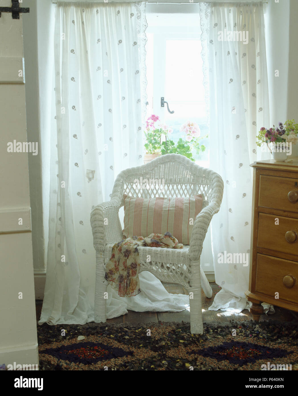 white wicker chair in front of window with white voile