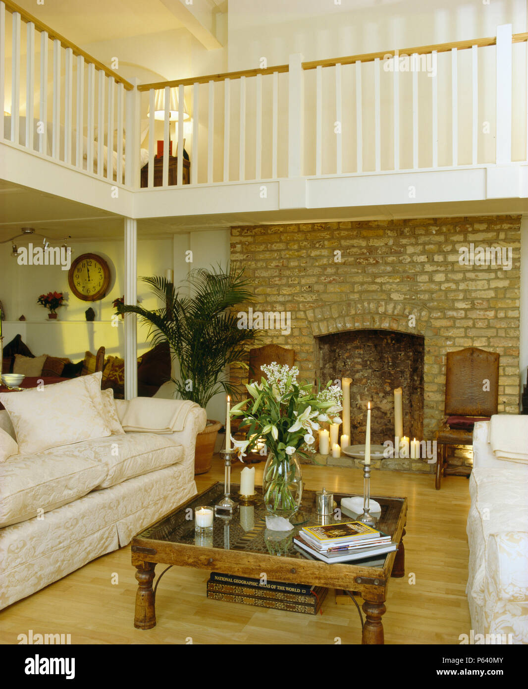 White sofas and ani Indonesian coffee table in galleried loft
