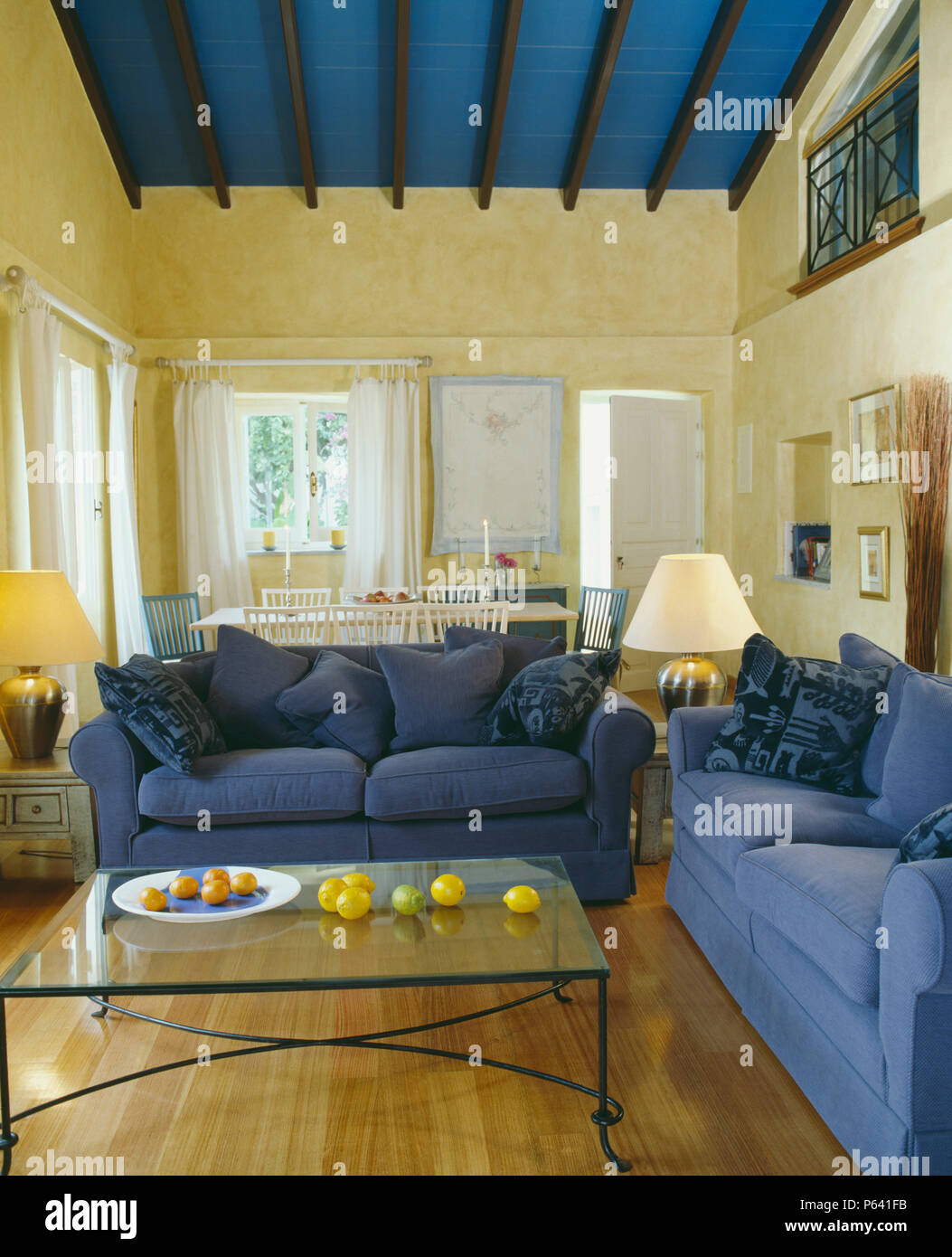 Blue Sofas And Glass Topped Coffee Table In Living Room With